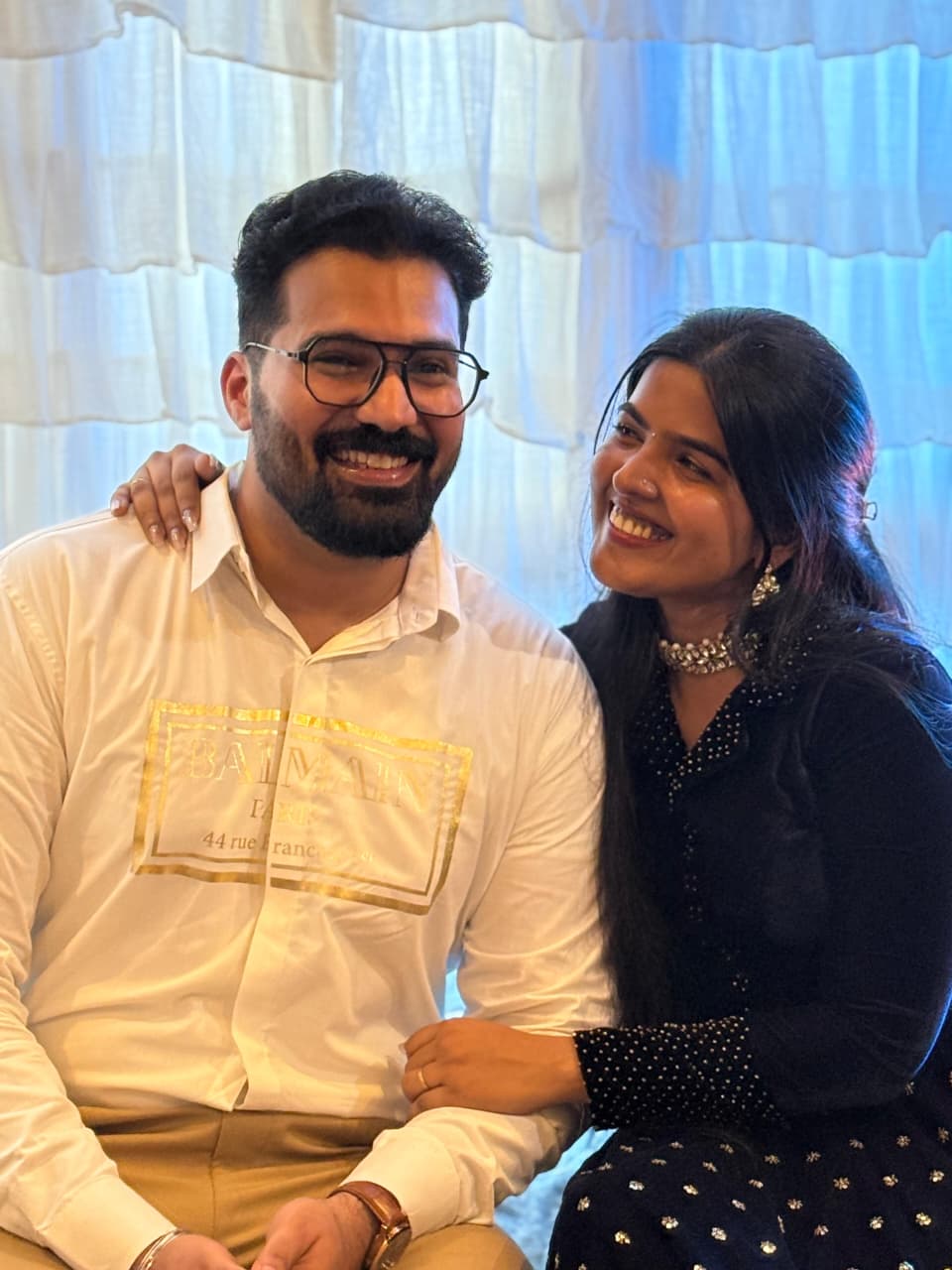 Couple seated together smiling in a warm indoor setting