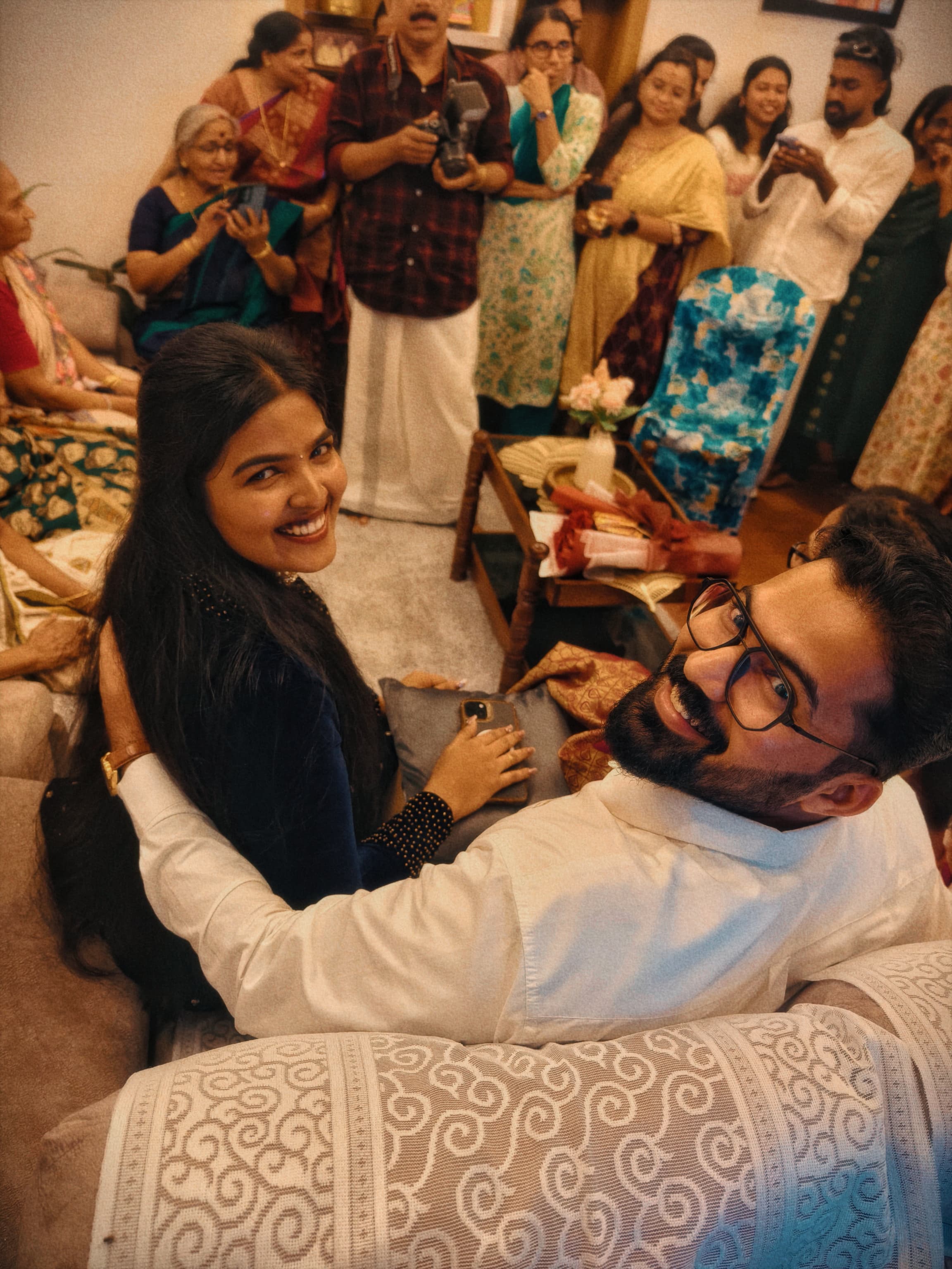 Couple seated on sofa turning back and smiling during a celebration